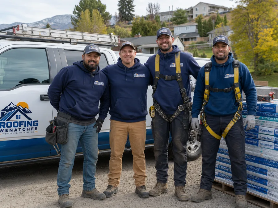 Roofing Wenatchee team in safety gear beside a work truck and neatly stacked materials at a residential job site